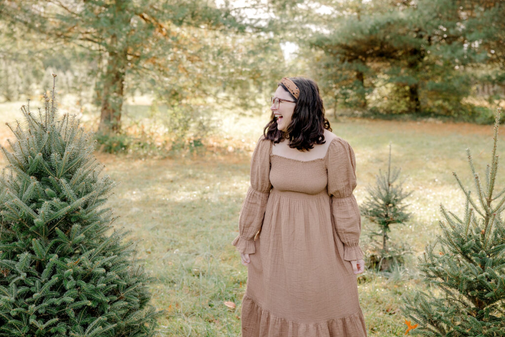 woman in a light brown dress laughing