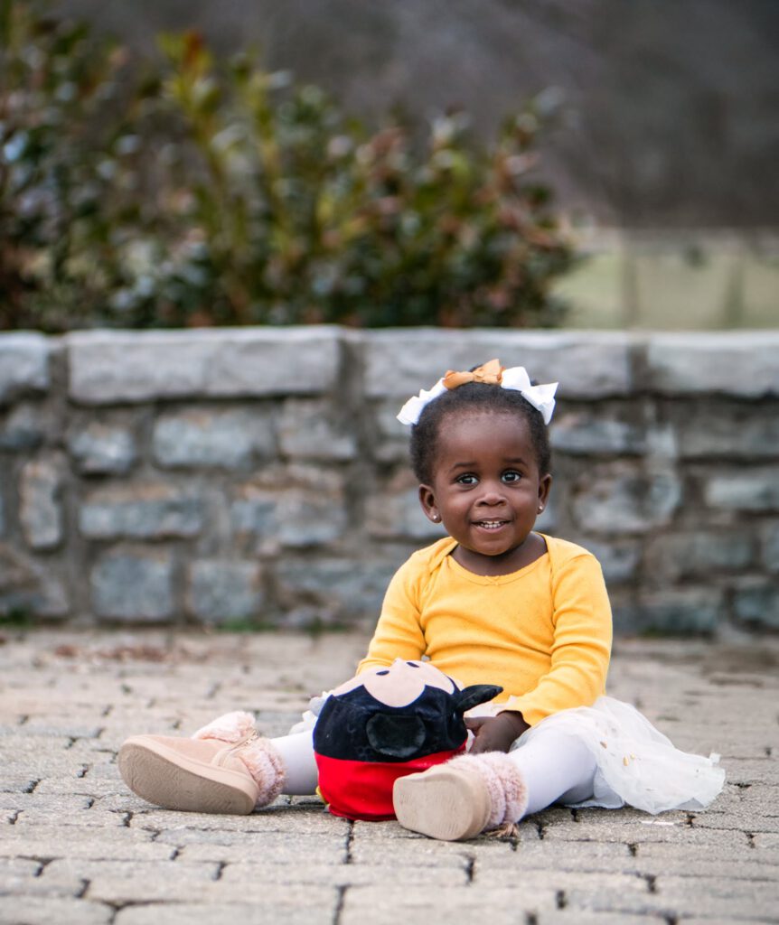 little girl sitting with her stuffed animal