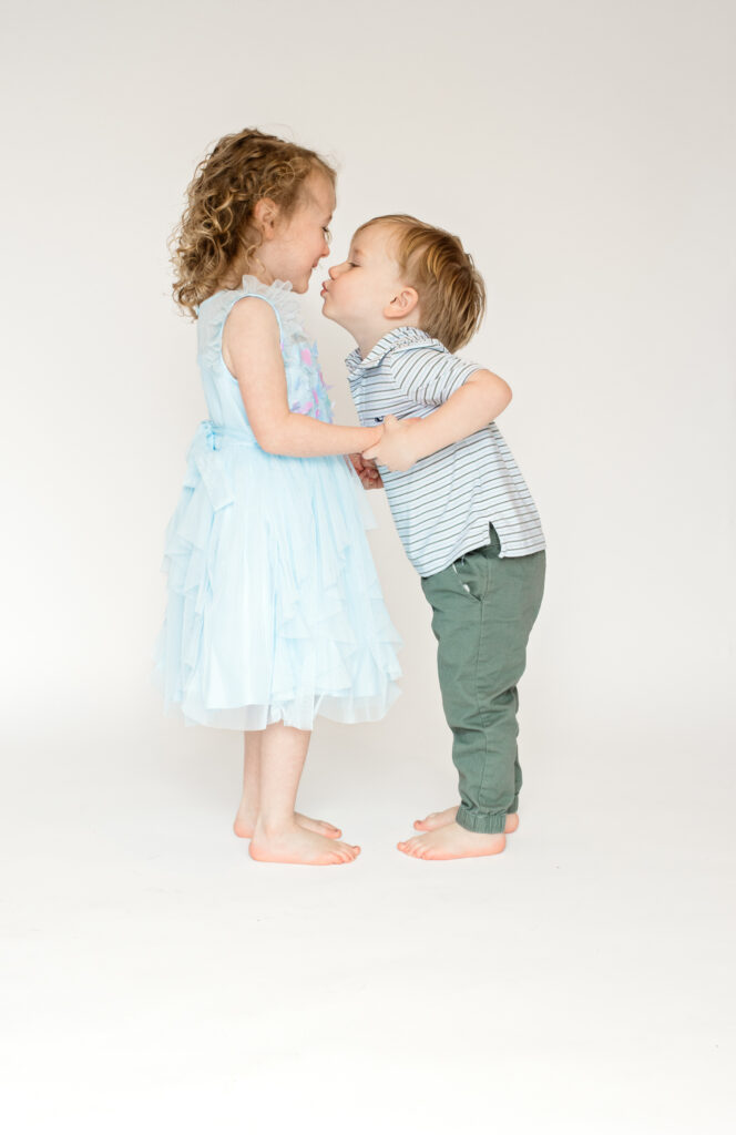 a brother and sister lean in for a kiss