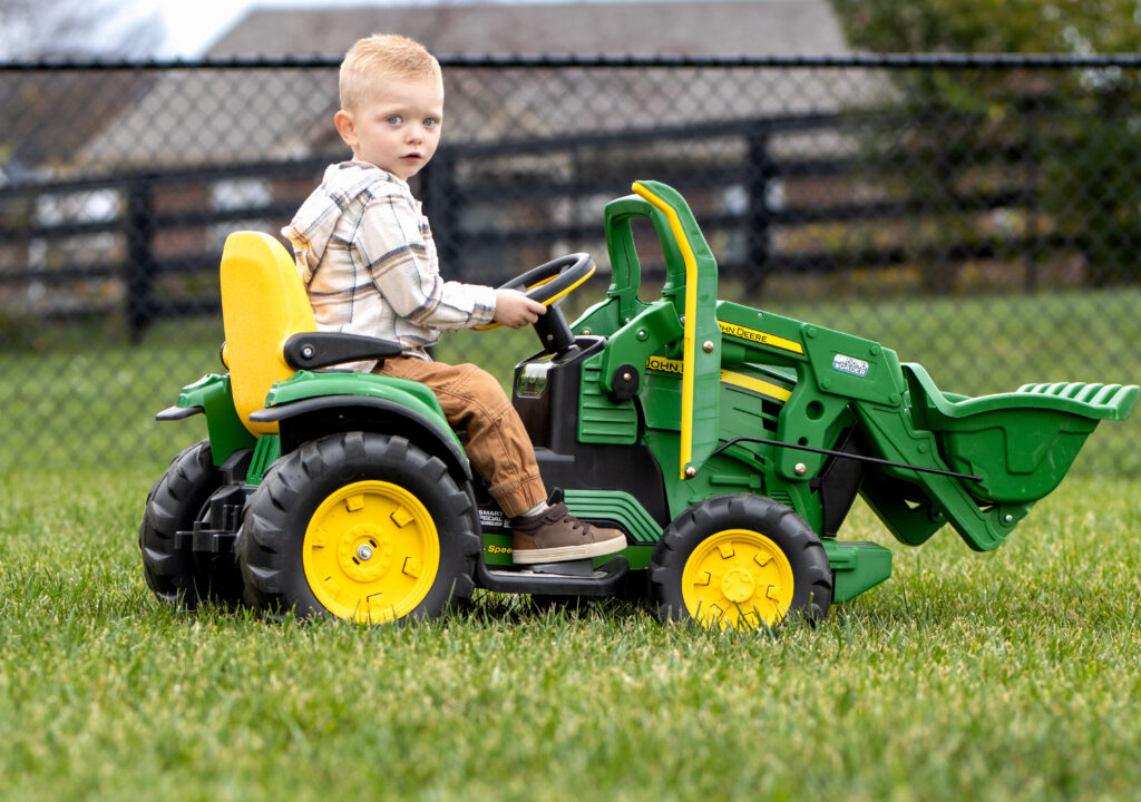boy riding on a toy tractor