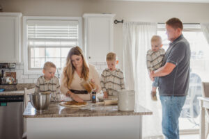 A family in their kitchen rolling dough
