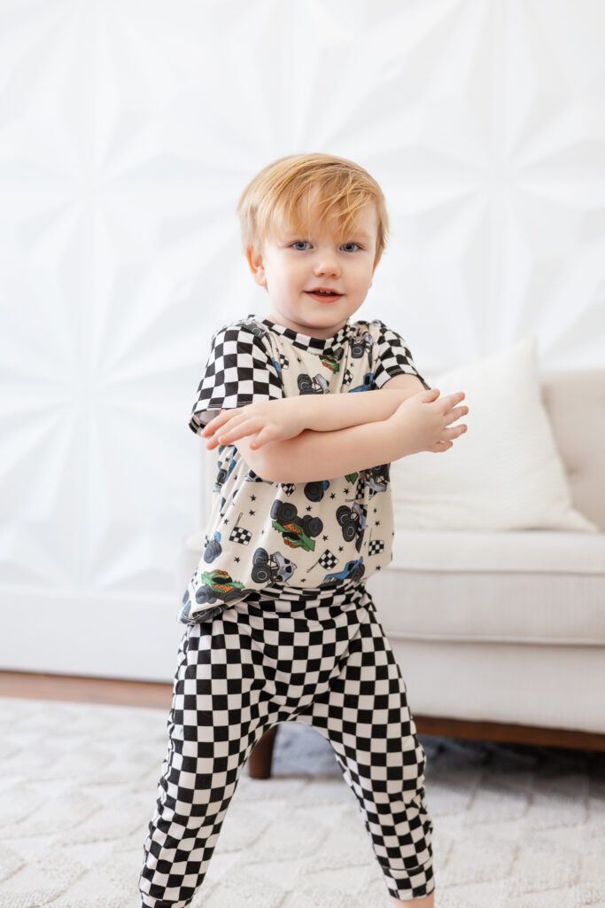 Little boy with arms crossed, wearing a checkered outfit