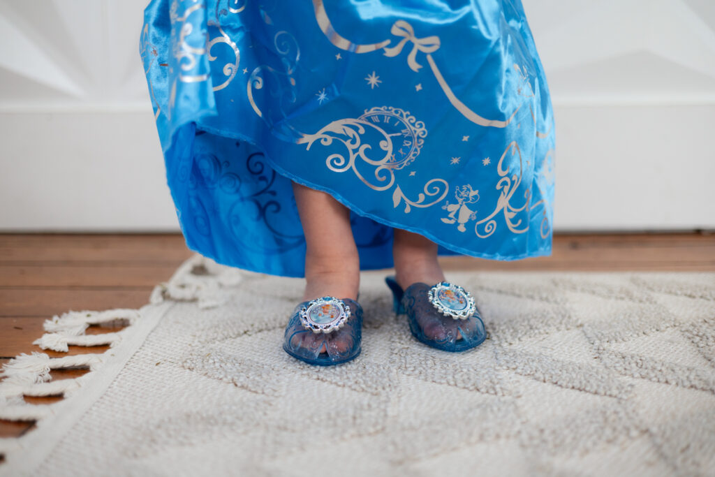 little girl wearing plastic princess shoes