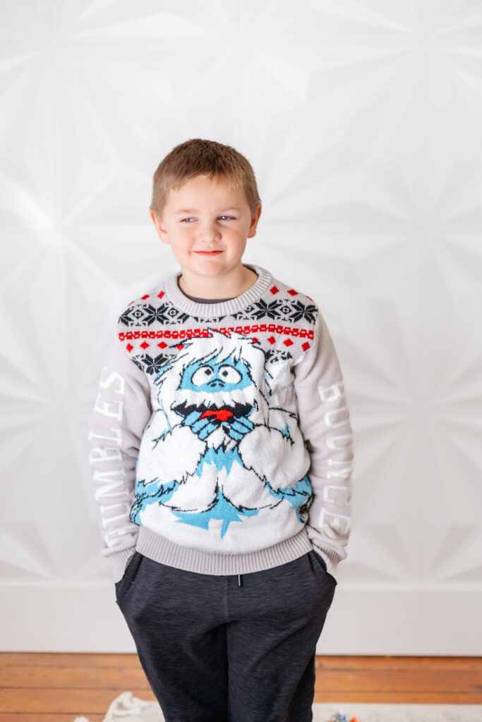 boy in a yeti sweater with a mischievous look on his face