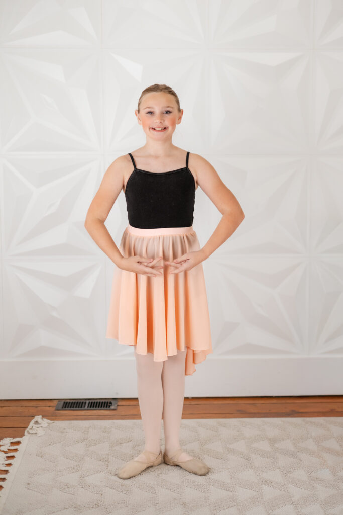 Girl wearing a leotard, standing in first position